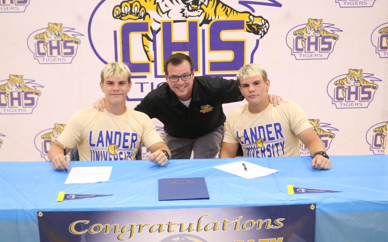 Columbia wrestlers Ian McGuigan (left) and Alex McGuigan (right) are pictured with head coach Pete Whittington (middle) after they signed their letters of intent with Lander on Thursday. (JORDAN KROEGER/Lake City Reporter)