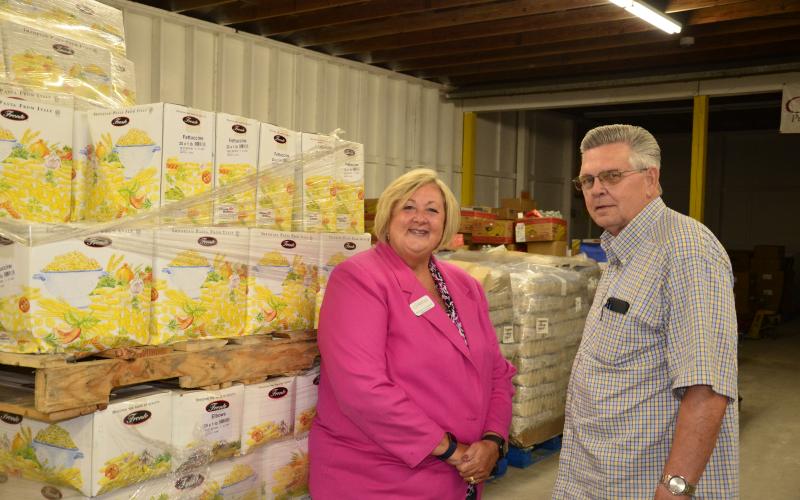 Suzanne Edwards and David Boozer pose together at the Catholic Charities building. The organization’s food bank program recently received a $30,000 donation from Nutrien to assist in the covid-19 relief effort. (CARL MCKINNEY/Lake City Reporter)