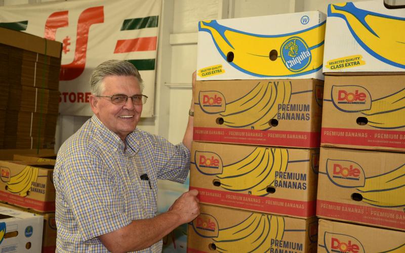 David Boozer, general manager of the Florida Gateway Food Bank, poses in front of the boxes that a shipment of bananas came in. (CARL MCKINNEY/Lake City Reporter)