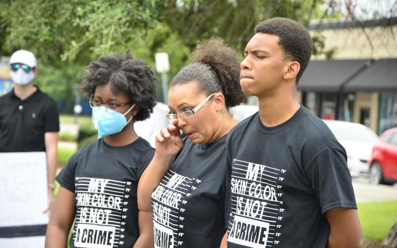 Protesters in matching shirts grieve together during a minutes-long period of silent reflection. Many people in the crowd could be seen wiping away tears. (CARL MCKINNEY/Lake City Reporter)