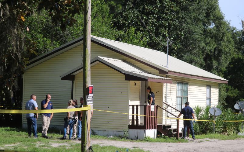 Bullet holes can be seen in the exterior of the house on NE Webster Avenue where a Lake City police officer was shot early Tuesday morning. (TONY BRITT/Lake City Reporter)