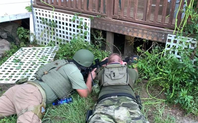 Suwannee County Sheriff’s Office SWAT team members look beneath the house where Anthony Riley was hiding Monday. (Courtesy Suwannee County Sheriff's Office)