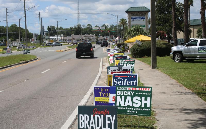 Only a few campaign workers braved 95-degree heat outside the Supervisor of Elections office Monday afternoon. (TONY BRITT/Lake City Reporter)