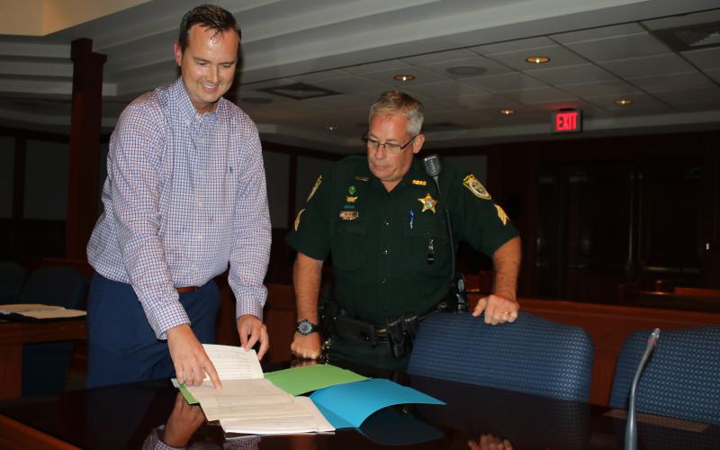 Jay Swisher, left, who will be sworn-in as the interim clerk of courts in a private ceremony today, reviews paperwork with Sgt. Mike Sweat of the Columbia County Sheriff’s Office Judicial Division. (TONY BRITT/Lake City Reporter)