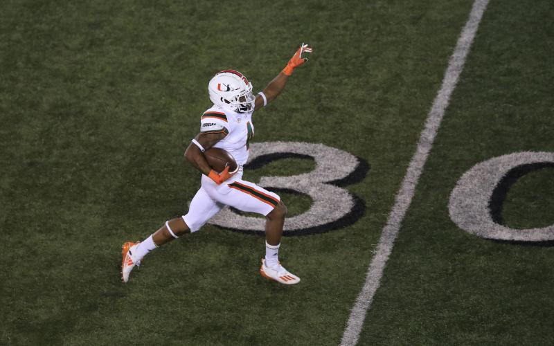 Miami Hurricanes running back Jaylan Knighton runs for a touchdown in the third quarter against Louisville at Cardinal Stadium Saturday night, in Louisville, Ky. Miami won, 47-34. (ANDY LYONS/Getty Images/TNS)