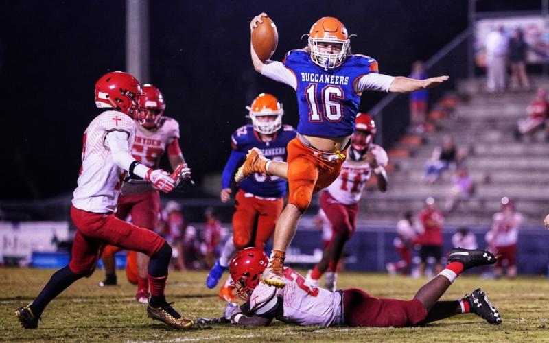 Branford’s Caden Coker leaps over a Bishop Snyder defender Friday night at Cleve Sikes Field at Buccaneer Stadium. (BRIAN LEWIS/Special to the Reporter)
