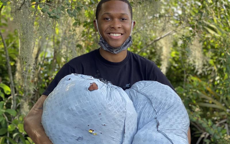 D’Andre Jefferson, holding bags of donated clothes, is hosting a clothing drive after being upset when he saw children mocked for the clothes they were wearing. (JAMIE WACHTER/Lake City Reporter)