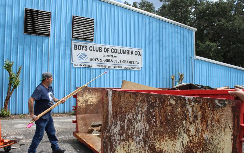 Scott Boisvert throws debris into a dumpster Thursday afternoon while cleaning out the old Boys Club of Columbia County facility. (TONY BRITT/Lake City Reporter)