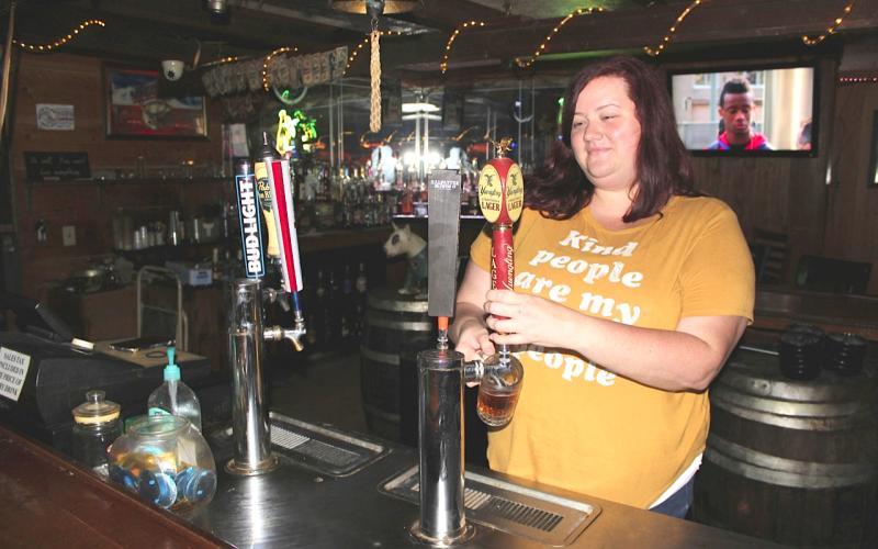 Longbranch Saloon Managing Partner Anita Irwin pulls a Yuengling draught for a customer soon after opening Monday afternoon. Florida bars were allowed to open at 50 percent capacity Monday after covid-19 shutdown restrictions were lifted by the governor. The Longbranch, one of Lake City’s oldest bars, re-opened as a non-smoking venue. (TODD WILSON/Lake City Reporter)