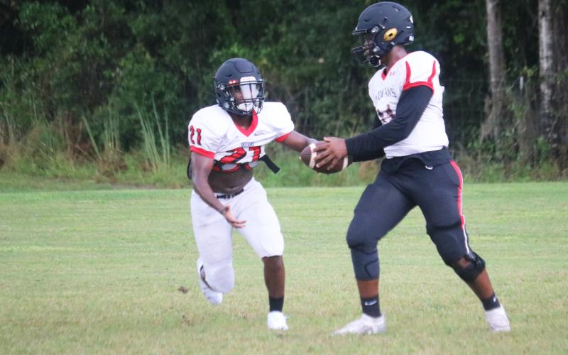 Fort White quarterback Tyler Jefferson hands the ball off to running back Tavion Taylor during Wednesday’s practice. The Indians open the season tonight at Santa Fe. (JORDAN KROEGER/Lake City Reporter)