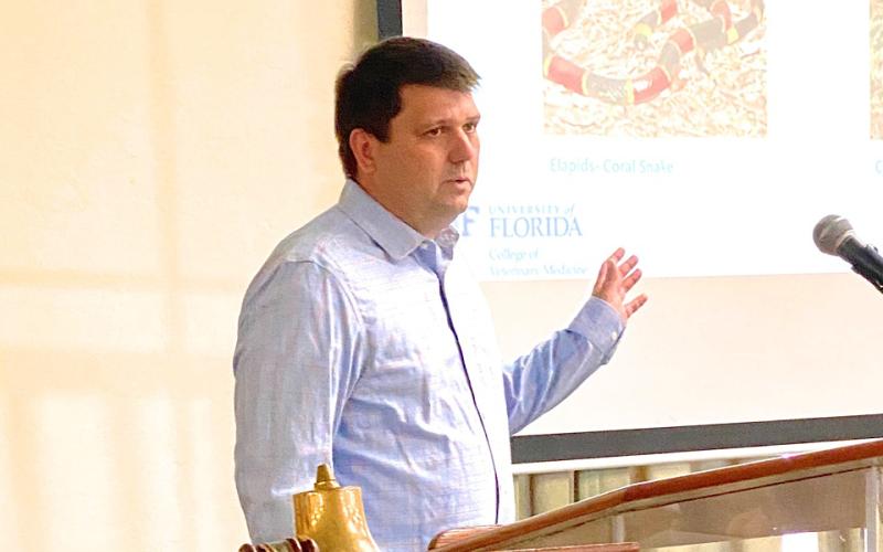 Dr. Travis Lanaux, DVM, emergency director of the University of Florida’s small animal hospital, talks about the treatment of snake bites in dogs during a presentation to the Rotary Club of Lake City Thursday. Lanaux talked about coral snake bites and strikes from pit vipers, including rattlesnakes, cottonmouths and copperheads. (TODD WILSON/Lake City Reporter)