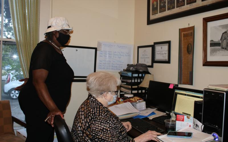 Paulette Lord (sitting), Lake City-Columbia County Historic Museum volunteer, and Lelia M. Williams, look through an application to secure a historical marker at the former Richardson High School site. Officials from the Historic Preservation, Division of Historical Resources, Florida Department of State, will notify them whether the site will get a historic marker on after Oct. 29. (TONY BRITT/Lake City Reporter)