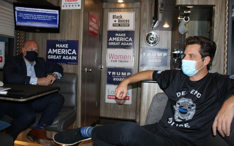 Former acting U.S. Attorney General Matthew Whitaker, left, and Florida Congressman Matt Gaetz talk aboard the Trump campaign bus prior to Monday’s rally at the Lake City Plaza. (TONY BRITT/Lake City Reporter)