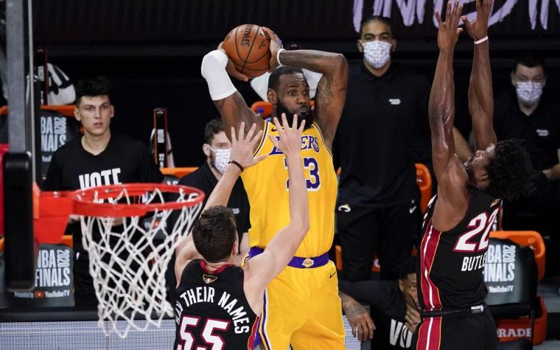 Los Angeles Lakers forward LeBron James passes between Miami Heat guard Duncan Robinson, left, and forward Jimmy Butler during the second half in Game 4 of the NBA Finals on Tuesday in Lake Buena Vista. (JOHN RAOUX/Associated Press)