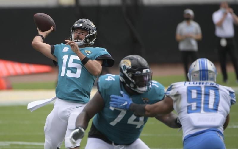 Jacksonville Jaguars quarterback Gardner Minshew II (15) throws a pass as offensive tackle Cam Robinson (74) blocks Detroit Lions defensive end Trey Flowers (90) on Oct. 18 in Jacksonville. (PHELAN M. EBENHACK/Associated Press)
