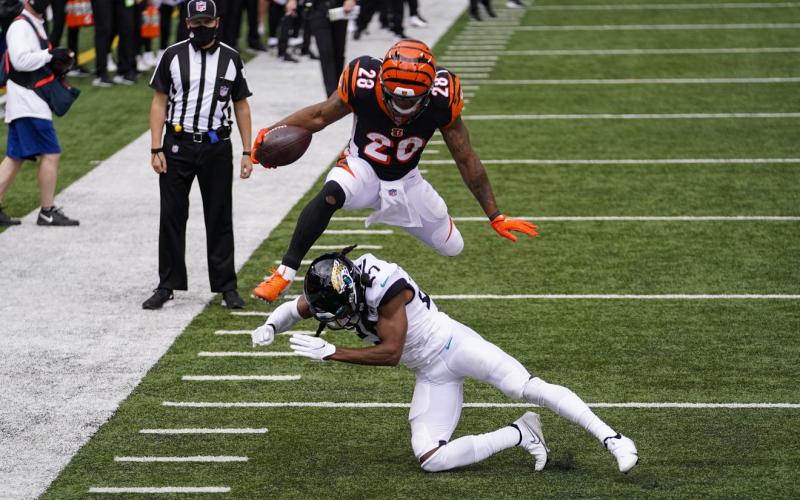 Cincinnati Bengals running back Joe Mixon (28) leaps over Jacksonville Jaguars cornerback Chris Claybrooks (27) for a touchdown on Sunday, in Cincinnati. (BRYAN WOOLSTON/Associated Press)