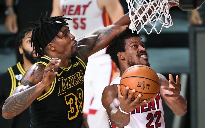 Los Angeles Lakers center Dwight Howard fouls Miami Heat forward Jimmy Butler (22) as he drives to the basket in the first quarter during Game 5 of the NBA Finals on Friday at AdventHealth Arena at ESPN Wide World Of Sports Complex in Lake Buena Vista. The Heat won, 111-108, to force a Game 6. (WALLY SKALIJ/Los Angeles Times/TNS