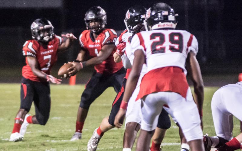 Fort White quarterback Tyler Jefferson hands the ball off to running back Tavion Taylor against Baldwin last Friday. (CHRISTINA FEAGIN/Special to the Reporter)