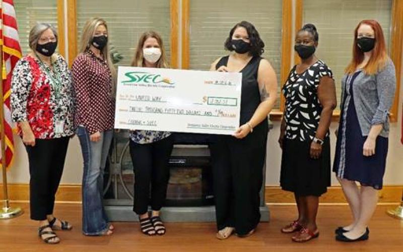 Suwannee Valley Electric Cooperative employees present Jennifer Anchors, the executive director of the United Way of Suwannee Valley with a check for $12,052, which includes a matching grant from CoBank. (COURTESY)