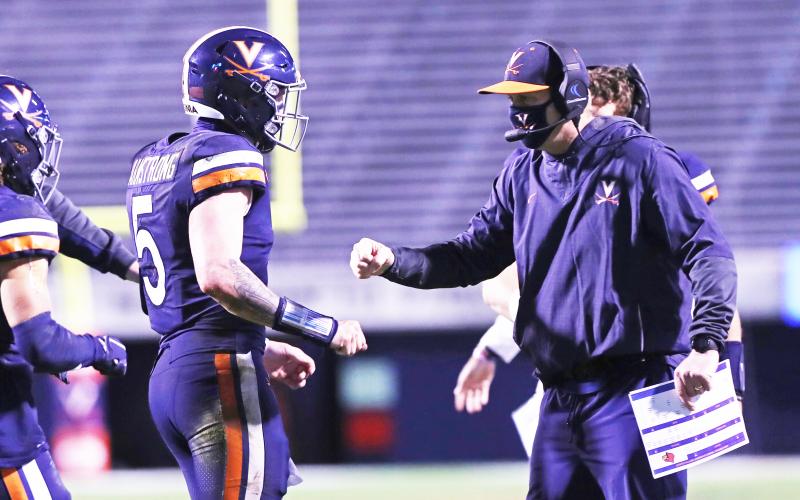 Virginia coach Bronco Mendenhall talks with quarterback Brennan Armstrong during a game against Louisville on Nov. 14 in Charlottesville. (ERIN EDGERTON/Daily Progress/TNS)