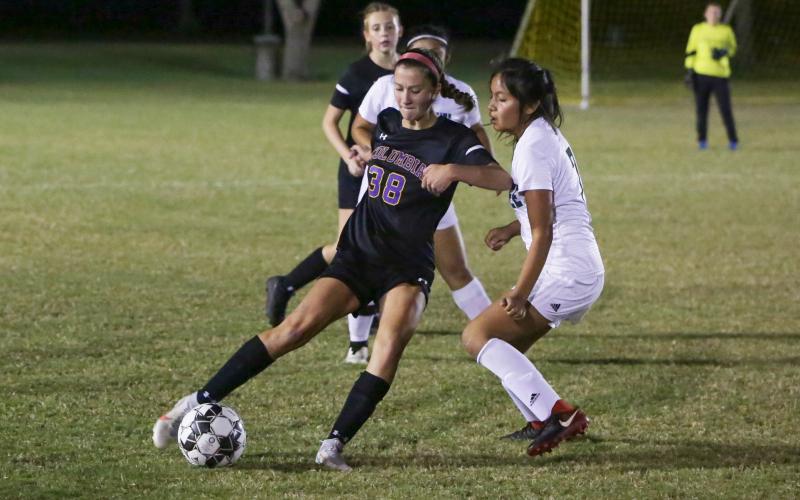 Columbia’s Skyler Ziegaus corrals possession from Suwannee’s Daisy De La Cruz on Thursday night. (BRENT KUYKENDALL/Lake City Reporter)