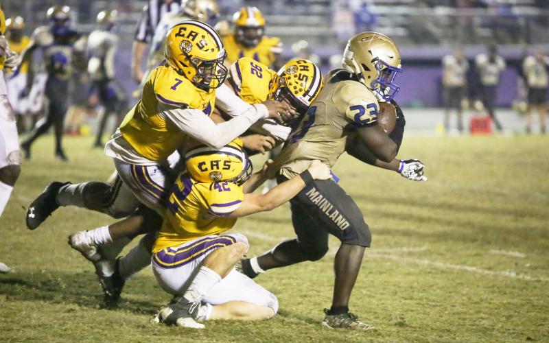 Columbia’s A’deon Farmer (7), Nate Walmsley (92) and Lane Mote (42) gang tackle Daytona Beach Mainland running back Gregory Mango during Friday’s Region 1-6A semifinal. (BRENT KUYKENDALL/Lake City Reporter)