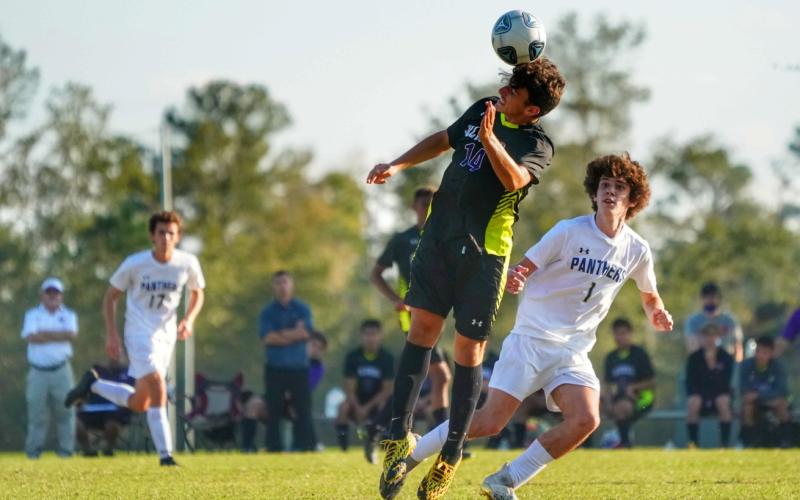 Columbia's john Saucer heads a ball during play against St. John Paul II on Saturday. (BRIAN LEWIS/Special to the Reporter)