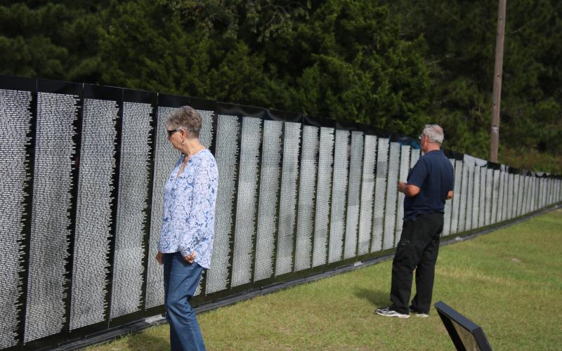 Nancy Chauncey and her husband Stanley Chauncey, of Lake City, look at names on the Vietnam Traveling Memorial Wall Thursday afternoon. The wall will be on display next door to the Honda of Lake City through Tuesday. (TONY BRITT/Lake City Reporter)
