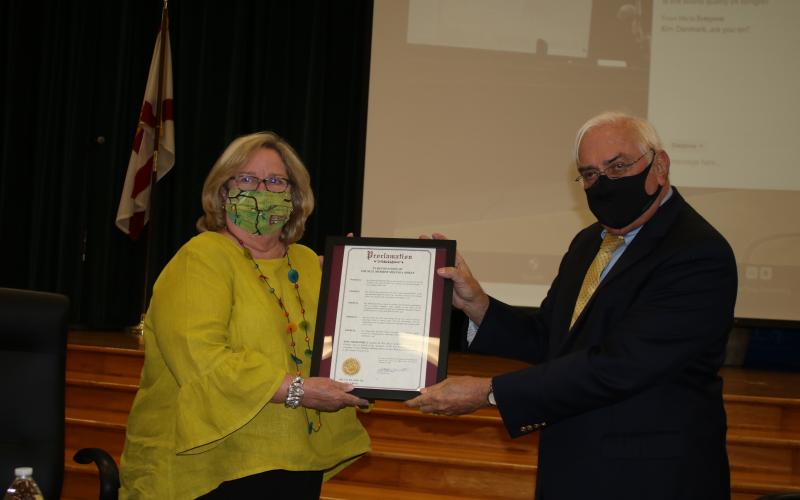 Melinda Moses (from left) stands with Lake City mayor Stephen Witt as the two show off a proclamation that was given to her in honor of her years of service to the city. She also received a plaque and a gift. Moses, who served as a city council member for 12 years, decided not seek re-election this year. (TONY BRITT/Lake City Reporter)