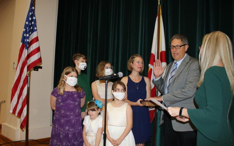 Lineah Sampson and Matilda Sampson (from row from left) stand with Lola Sampson (back row from left) Hannah Sampson, Aubree Sampson and Laura Sampson as Todd Sampson recites his oath of office Monday night. (TONY BRITT/Lake City Reporter)