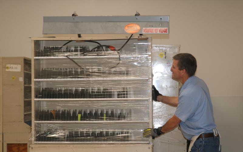 A mail sorting station is moved into the new Live Oak Post Office on Saturday in preparation of Monday’s opening. (JAMIE WACHTER/Lake City Reporter)