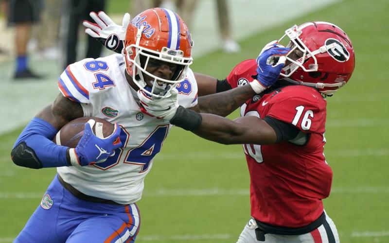 Florida tight end Kyle Pitts (84) tries to get past Georgia defensive back Lewis Cine (16) after a reception on Saturday in Jacksonville. (JOHN RAOUX/Associated Press)
