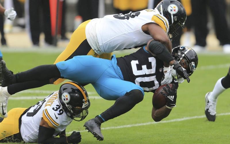 Jacksonville Jaguars running back James Robinson (30) is brought down by Pittsburgh Steelers linebacker Vince Williams, top, and safety Minkah Fitzpatrick (39) on Nov. 22 in Jacksonville. (MATT STAMEY/Associated Press)