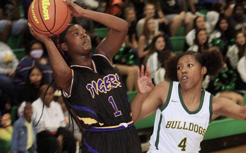 Columbia guard Anzarria Jerkins takes a shot as Suwannee guard V'kaylynn Ward defends on Saturday night. (PAUL BUCHANAN/Special to the Reporter)