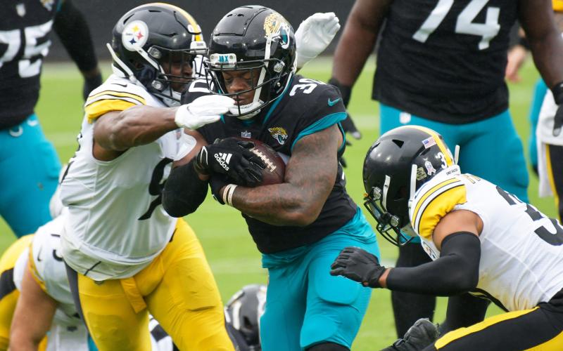 Jaguars running back James Robinson (30) is hit by Pittsburgh Steelers inside linebacker Vince Williams (98) and free safety Minkah Fitzpatrick (39) during a Nov. 22 game. (WILL DICKEY/TNS)