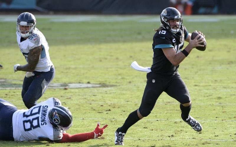 Jacksonville Jaguars quarterback Gardner Minshew II (15) scrambles away from Tennessee Titans defensive tackle Jeffery Simmons (98) on Sunday in Jacksonville. (PHELAN M. EBENHACK/Associated Press)