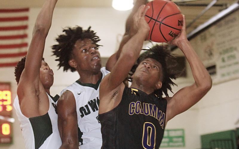 Columbia guard Dante Brown goes up for a shot as Suwannee forward Anthony Brown defends on Saturday night. (PAUL BUCHANAN/Special to the Reporter)