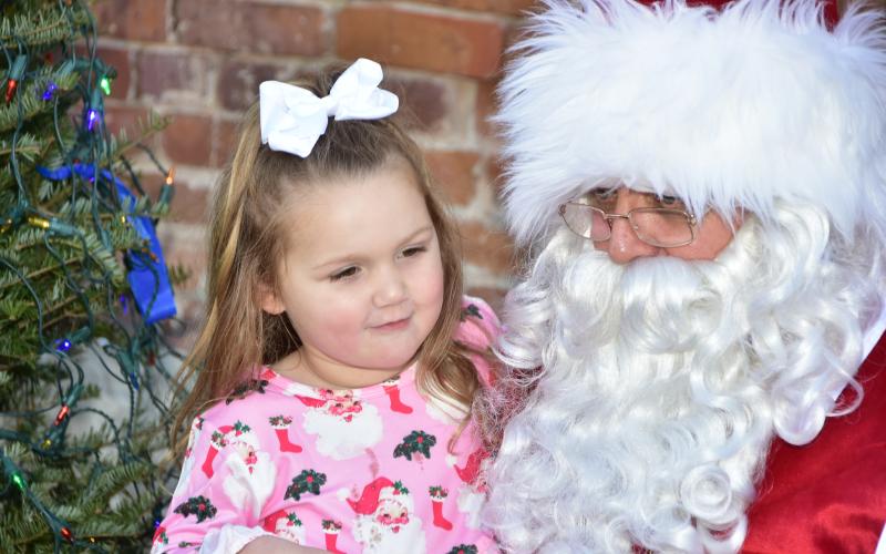 Santa Claus listens to a girl’s wish list Saturday at the 36th annual Christmas on the Square in Live Oak. (ROB WOLFE/Special to the Reporter)