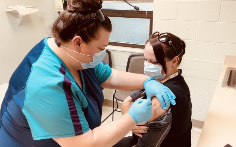 Front line staff member Sara Driggers (left) administers the first Moderna covid-19 vaccine allocated to the Columbia County Health Department to Sarah White. The health department will begin administering vaccinations to residents, 65 and older, on Monday. (COURTESY)