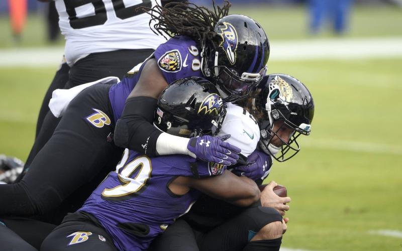 Jacksonville Jaguars quarterback Gardner Minshew II, right, is sacked for a safety by Baltimore Ravens linebacker Pernell McPhee (90) and linebacker Matthew Judon (99) on Sunday in Baltimore. (NICK WASS/Associated Press)