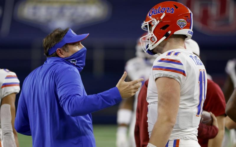 Florida coach Dan Mullen talks with quarterback Kyle Trask after Trask threw a pass into the end zone that was intercepted by Oklahoma's Woodi Washington during the first half of the Cotton Bowl on Wednesday in Arlington, Texas. (RON JENKINS/Associated Press)