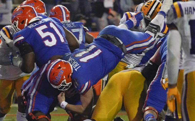 Florida quarterback Kyle Trask (11) dives over the LSU defense for a 1-yard touchdown on Saturday in Gainesville. (JOHN RAOUX/Associated Press)