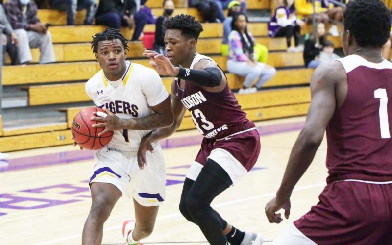 Columbia guard Tray Tolliver looks to pass as Madison County guard Jamie Hampton defends on Thursday. (BRENT KUYKENDALL/Lake City Reporter)