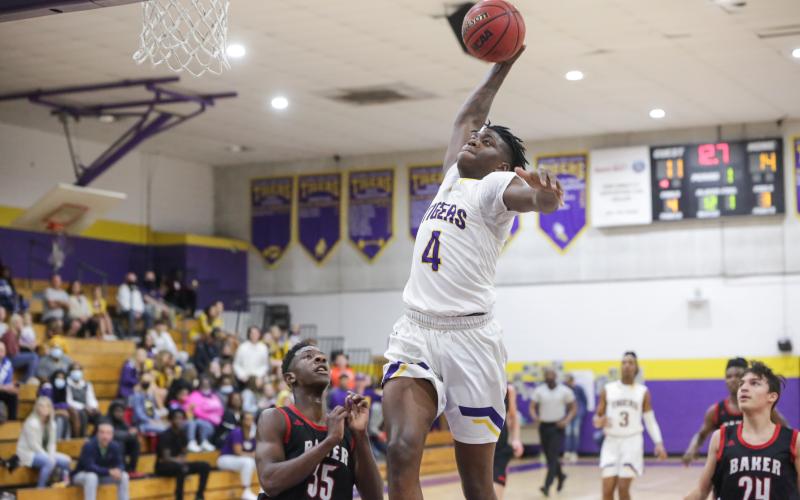 Columbia forward Marcus Peterson flies toward the basket for a slam dunk against Baker County on Friday night. Peterson finished with a game-high 16 points for the Tigers. (BRENT KUYKENDALL/Lake City Reporter)