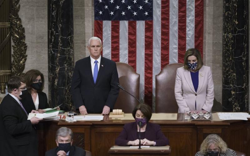 Vice President Mike Pence and Speaker of the House Nancy Pelosi, D-Calif., read the final certification of Electoral College votes cast in November's presidential election during a joint session of Congress after working through the night and into Thursday at the Capitol in Washington. Violent protesters loyal to President Donald Trump stormed the Capitol Wednesday, disrupting the process. (J. SCOTT APPLEWHITE/AP Pool Photo)
