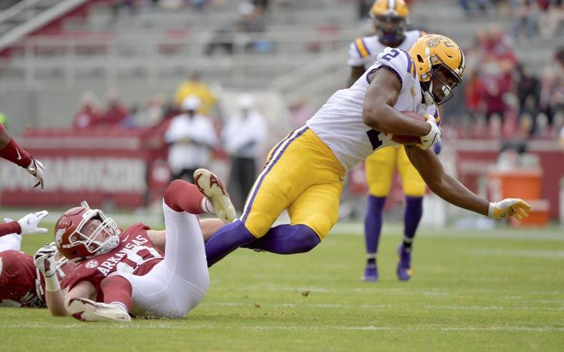U tight end Arik Gilbert (2) is tripped up by Arkansas defender Bumper Pool (10) in Nov. 21, 2020, in Fayetteville, Ark. (MICHAEL WOODS/Associated Press)