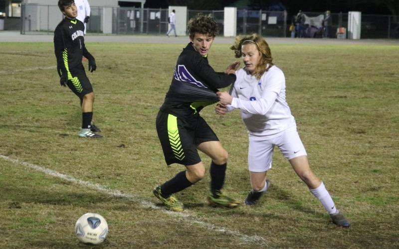 Columbia’s Trey Hingson chases after possession of the ball with Clay’s Ryan Borsheim on Thursday. (JORDAN KROEGER/Lake City Reporter)