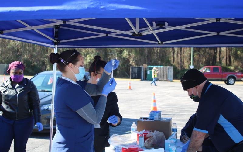 Sara Driggers fills a syringe with the Moderna covid-19 vaccination Monday morning as local residents 65 and older get inoculated. The Columbia County Health Department vaccinated 530 people on Monday. Roughly 3,200 people have registered for the vaccination already. (TONY BRITT/Lake City Reporter)