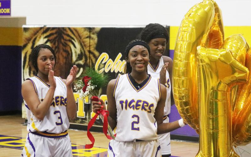 Columbia point guard Na’Haviya Paxton is congratulated by teammates after scoring the 1,000th point of her career during the second quarter of Thursday’s game against Countryside Christian. Paxton was presented with a bronze basketball trophy, balloons, flowers and a poster signed by all of her teammates that read, ‘Na’Haviya gets 1,000 buckets.’ (JORDAN KROEGER/Lake City Reporter)