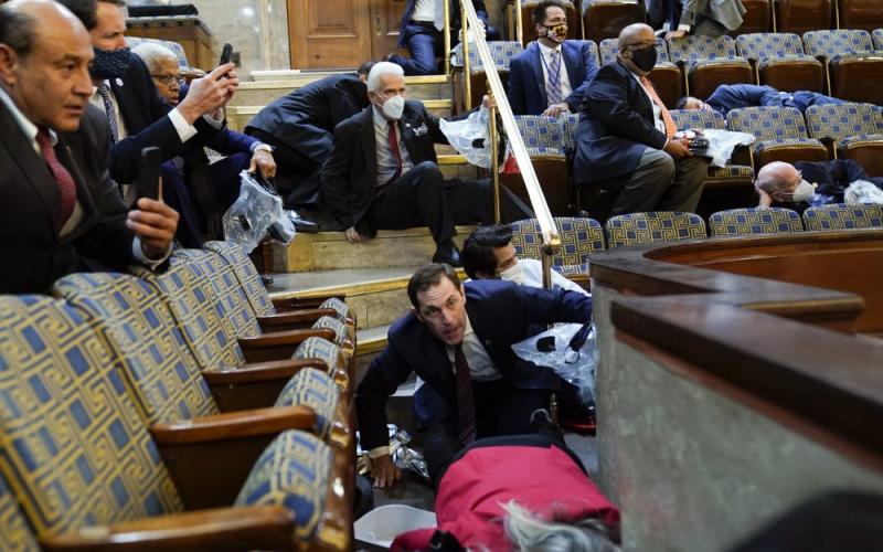 People shelter in the House gallery as protesters try to break into the House Chamber at the U.S. Capitol on Wednesday in Washington. (ANDREW HARNIK/Associated Press)